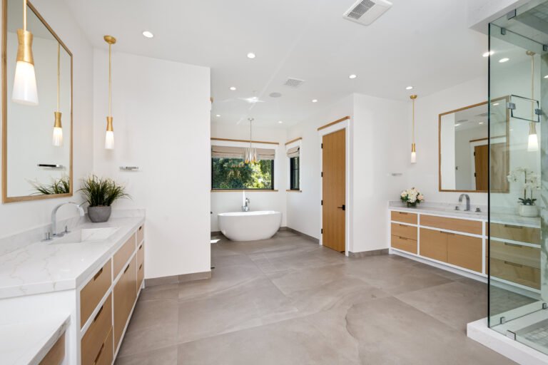 A bathroom with marble countertops and a spacious white tub