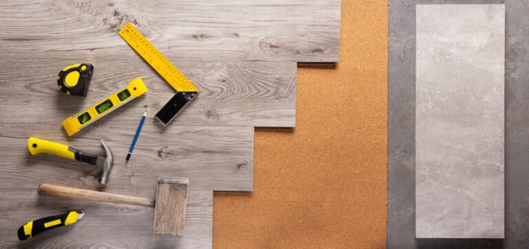 Construction tools laid out on wood laminate floor.