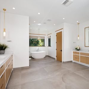 A bathroom with marble countertops and a spacious white tub